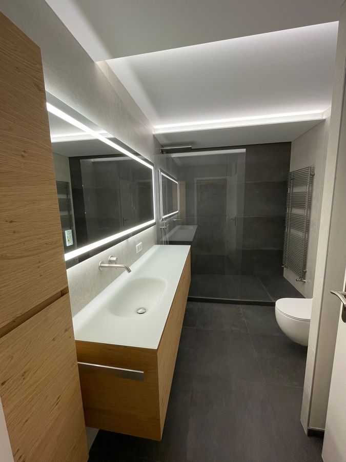 Une salle de bain avec lavabo, WC et miroir.