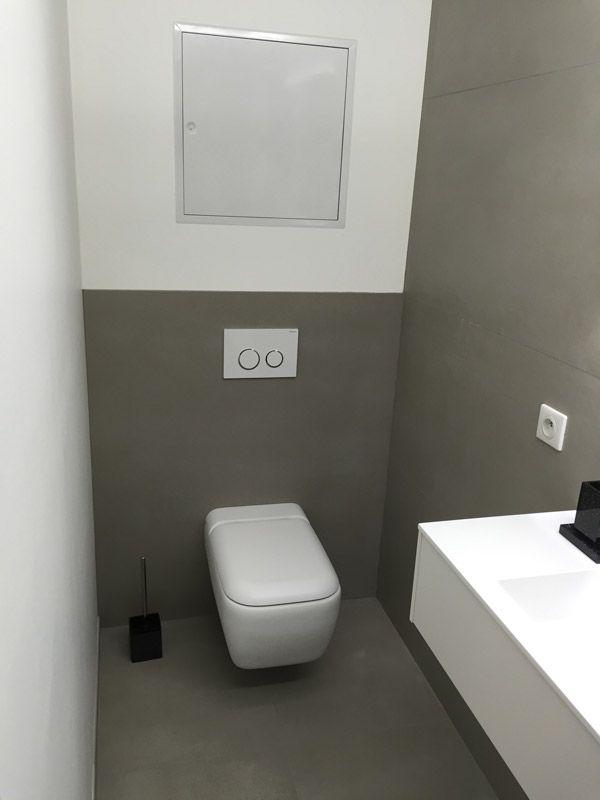 Une salle de bain avec WC, lavabo et miroir.