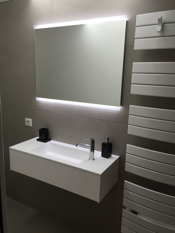 Une salle de bain avec un lavabo et un grand miroir