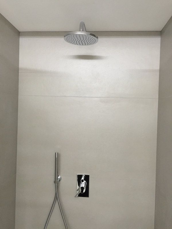 Une pomme de douche est suspendue au plafond dans une salle de bain