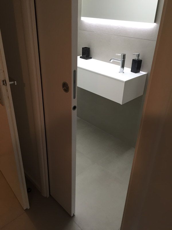 Une salle de bain avec un lavabo, un miroir et un distributeur de savon.