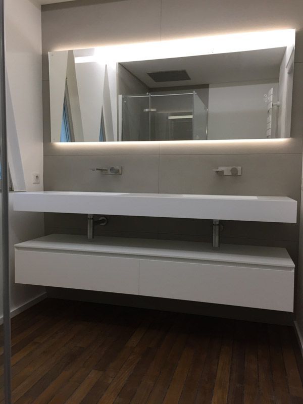 Une salle de bain avec deux lavabos et un grand miroir