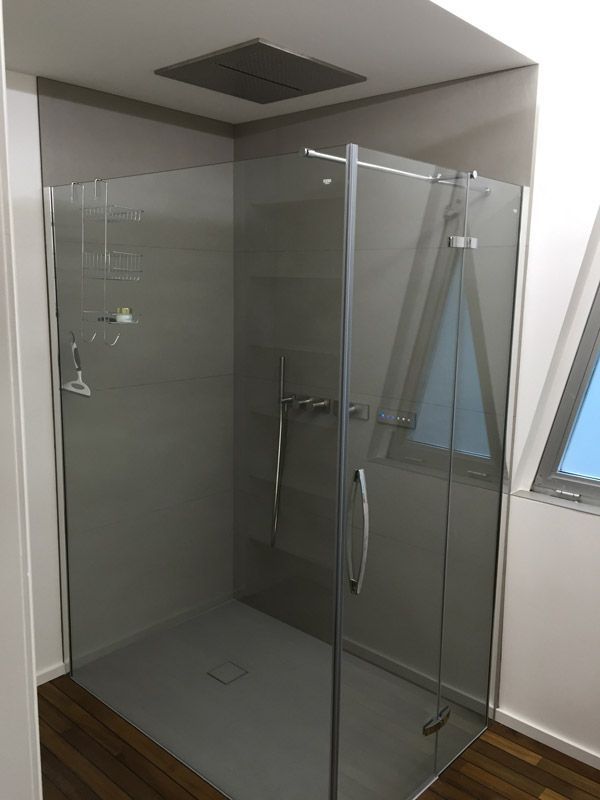 Une salle de bain avec douche à l'italienne et fenêtre.