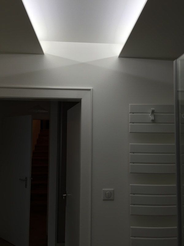 Une pièce sombre avec une lumière provenant du plafond