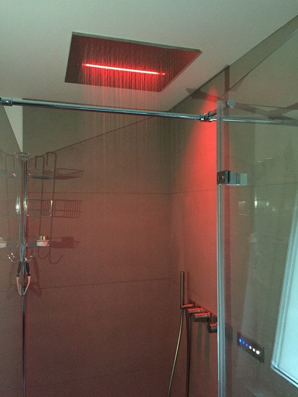 Une douche avec une lumière rouge au plafond