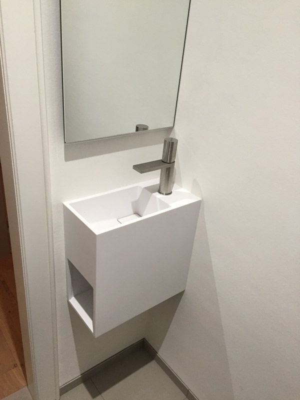 Une salle de bain avec un lavabo et un miroir au mur