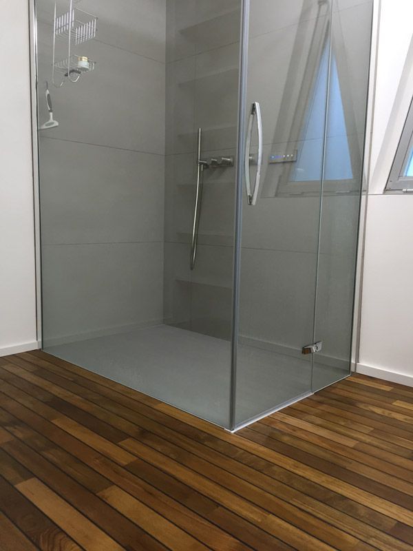 Une salle de bain avec douche à l'italienne et un parquet au sol.
