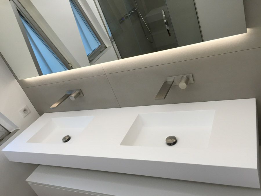 Une salle de bain avec deux lavabos et un grand miroir