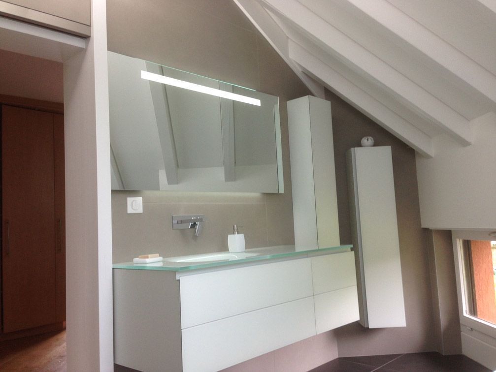 Une salle de bain avec des armoires blanches et un grand miroir