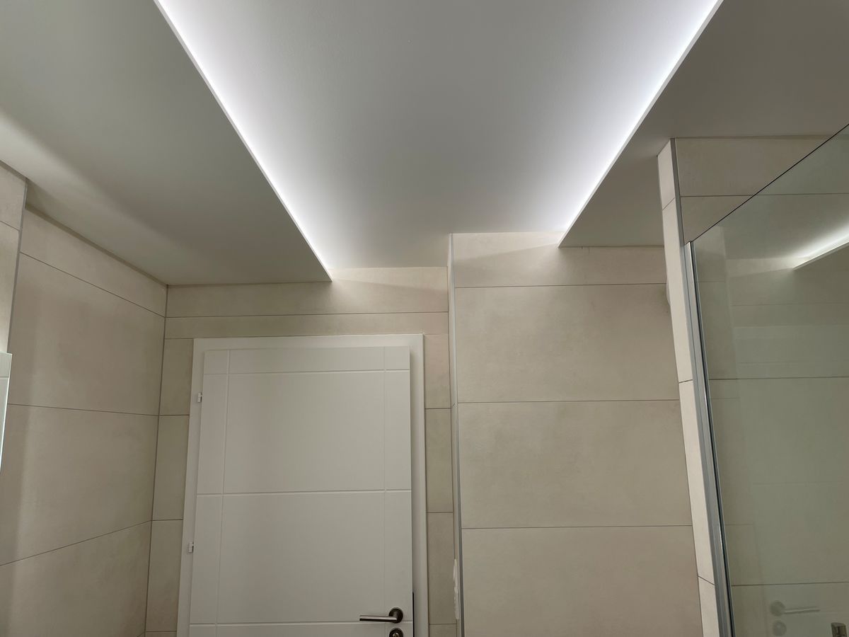 Une salle de bain avec un plafonnier et une porte.