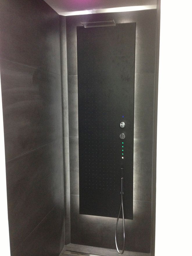 Une salle de bain avec douche et un miroir au mur