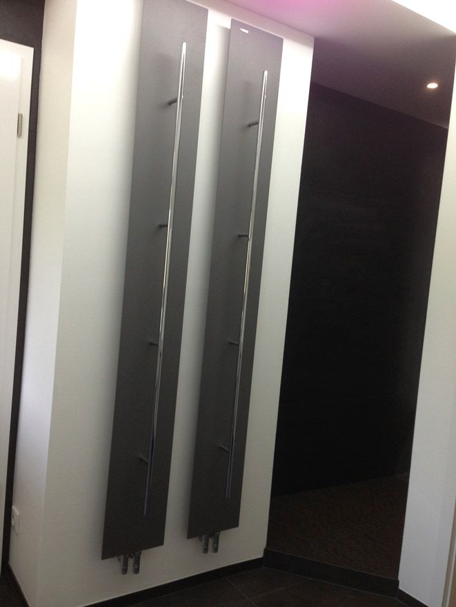 Un couloir avec une rangée de boîtes grises sur le mur