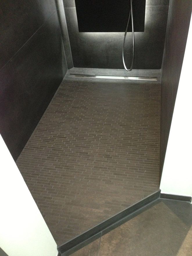 Une salle de bain avec douche à l'italienne et sol carrelé