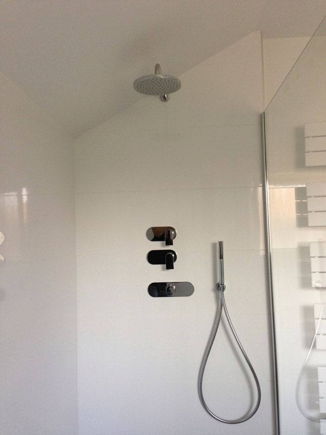 Une pomme de douche est suspendue au plafond dans une salle de bain