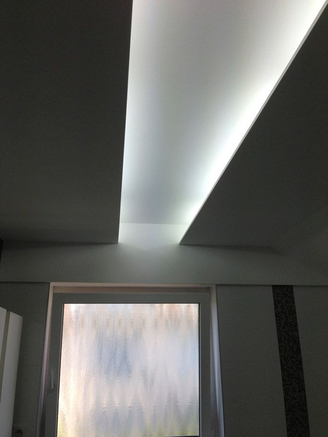 Une pièce avec une fenêtre et un plafond blanc