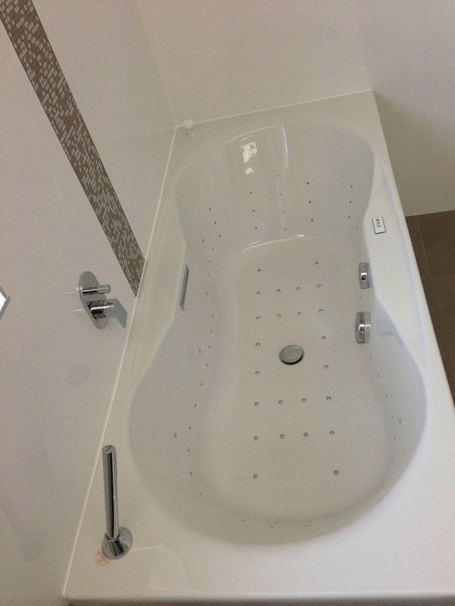 Une baignoire blanche dans une salle de bain avec des trous