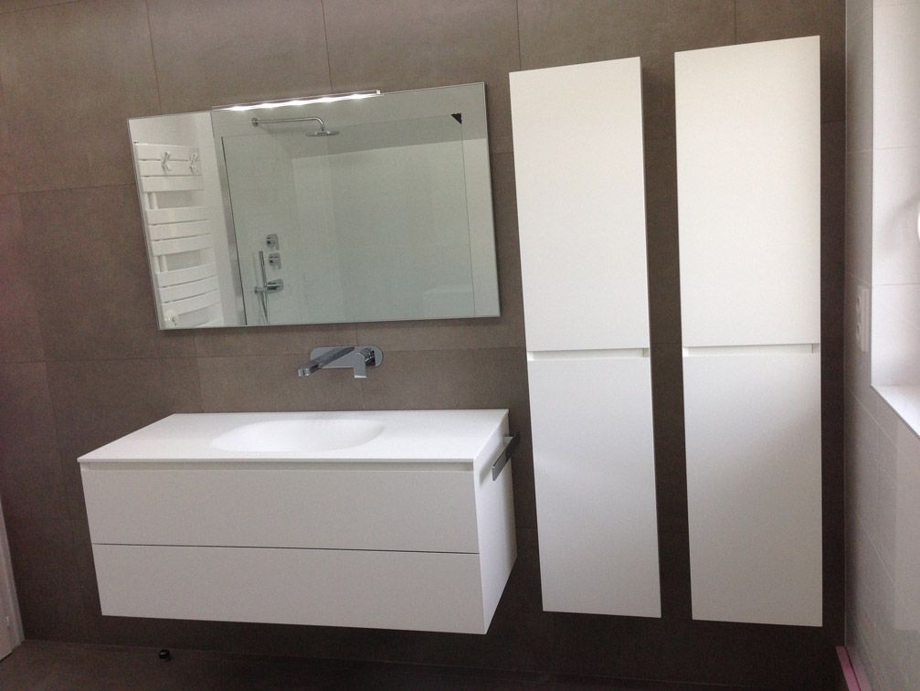 Une salle de bain avec un lavabo, un miroir et des armoires