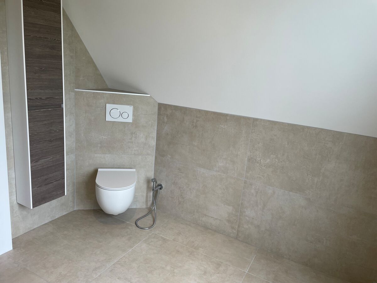 Une salle de bain avec WC et WC suspendu