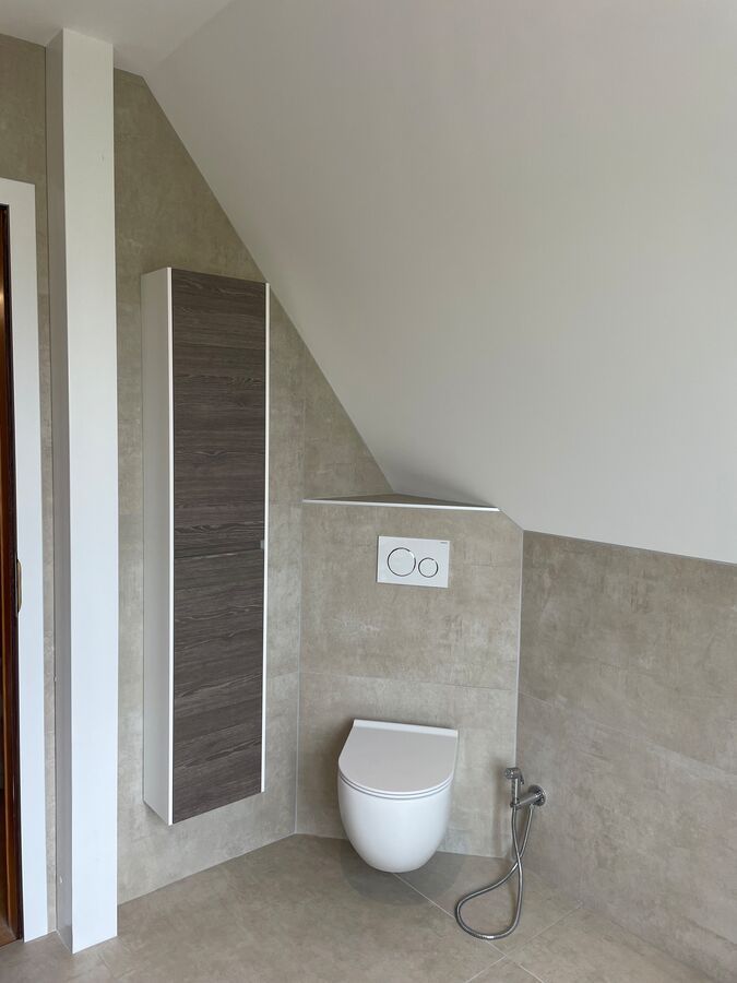 Il y a des toilettes dans le coin de la salle de bain.