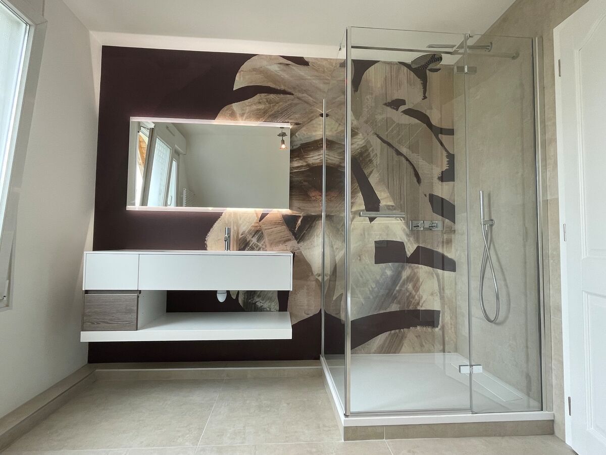 Une salle de bain avec une douche à l'italienne, un lavabo et un miroir