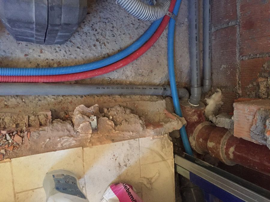 Un tas de tuyaux sont reliés à un mur.