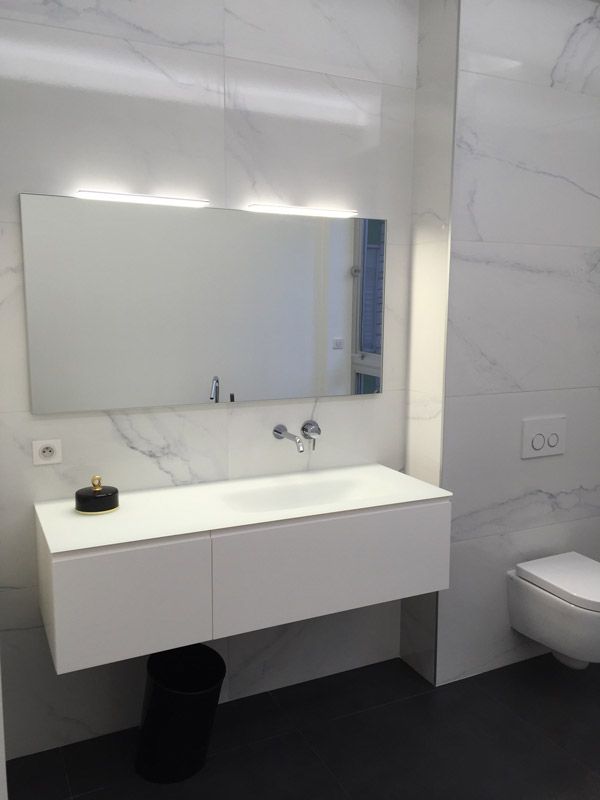 Une salle de bain avec un lavabo, un miroir et des toilettes