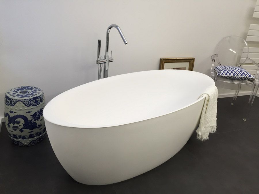 Une baignoire blanche dans une salle de bain à côté d'une chaise