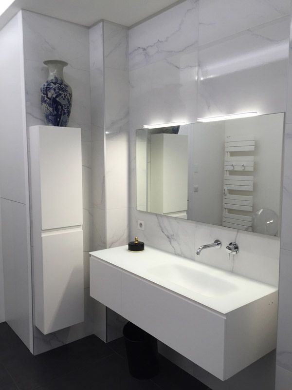 Une salle de bain avec un grand lavabo et un miroir