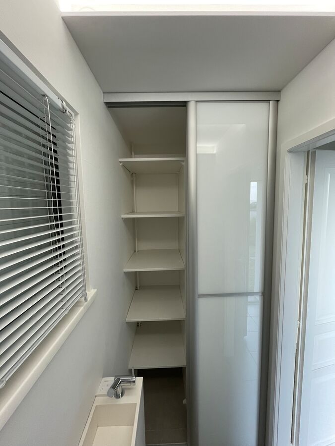 Une salle de bain avec un lavabo et une porte coulissante en verre