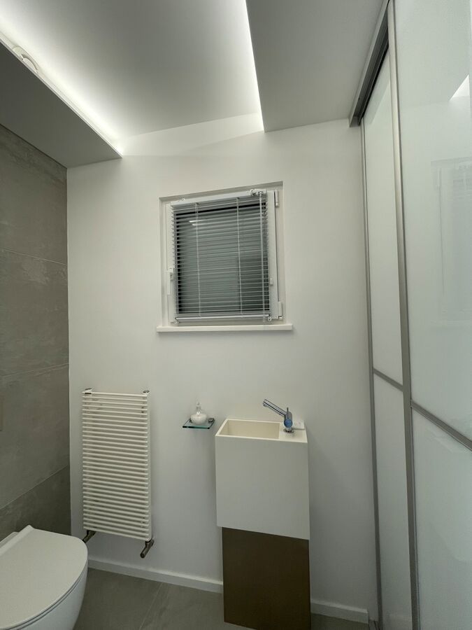 Une salle de bain avec des toilettes, un lavabo et une fenêtre