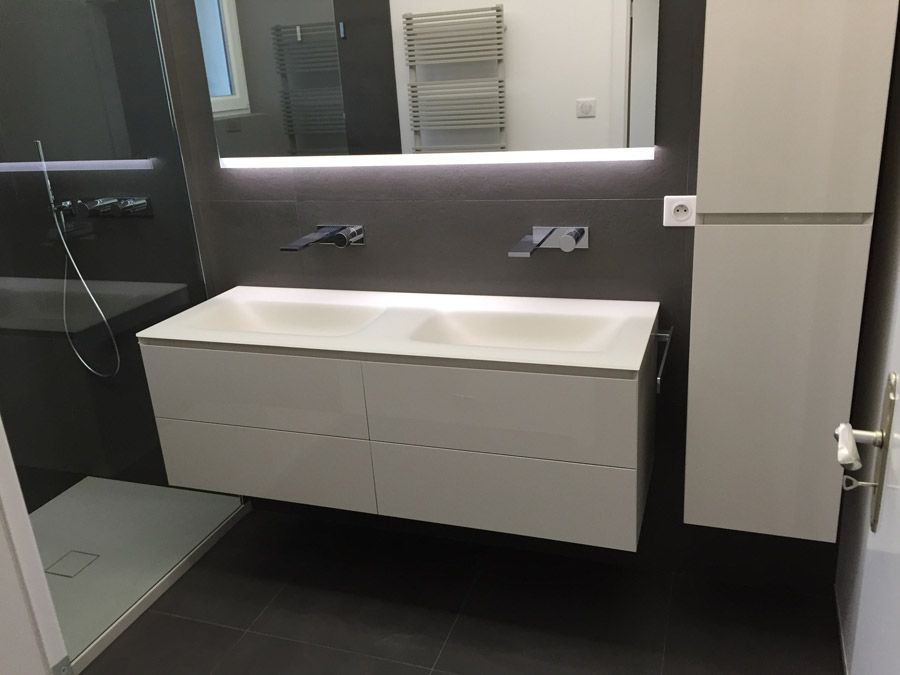 Une salle de bain avec deux lavabos et un miroir