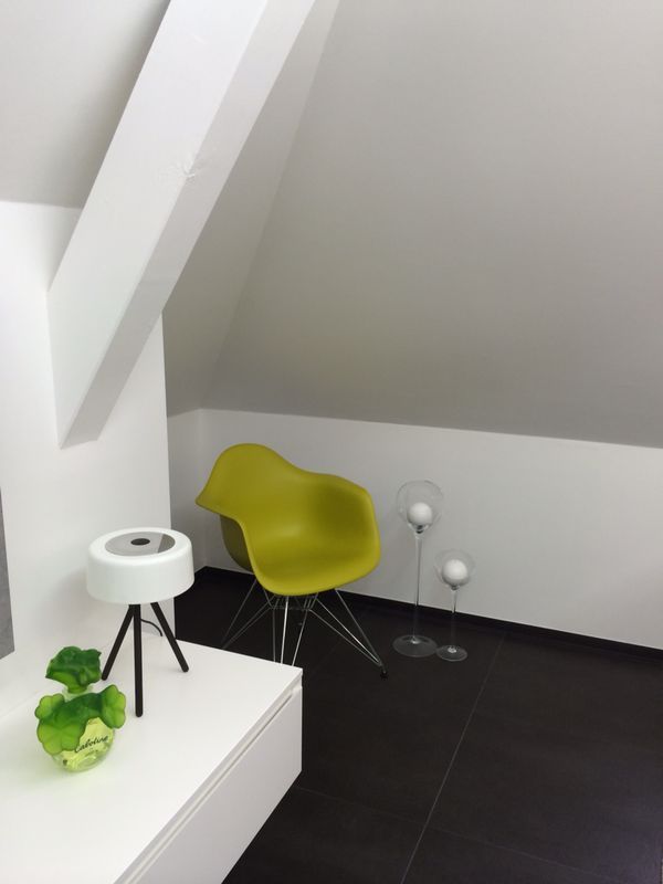 Une chaise jaune se trouve dans un coin d'une pièce