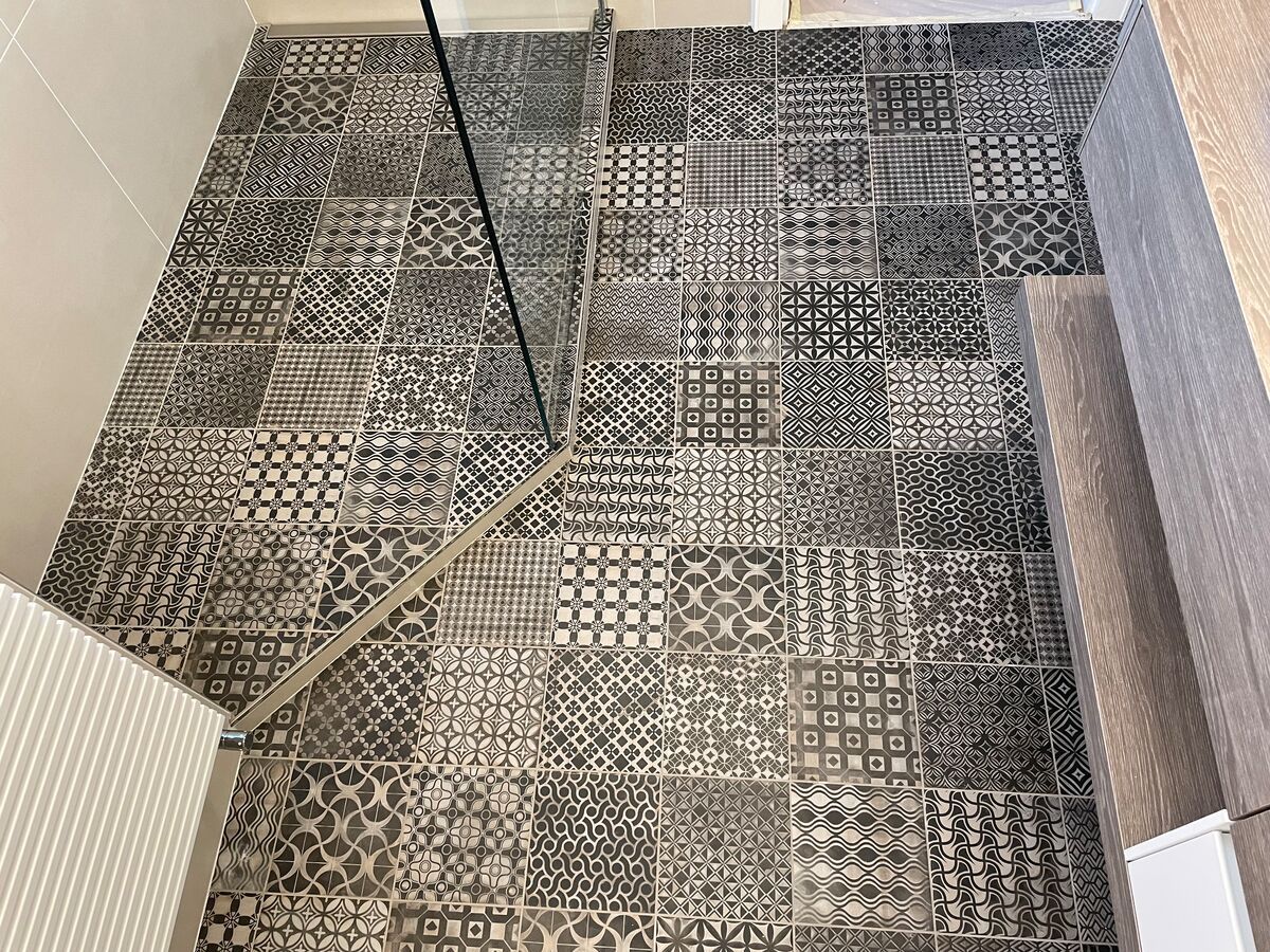 Une salle de bain avec un sol carrelé et une douche à l'italienne.