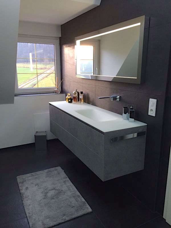 Une salle de bain avec un lavabo et un grand miroir