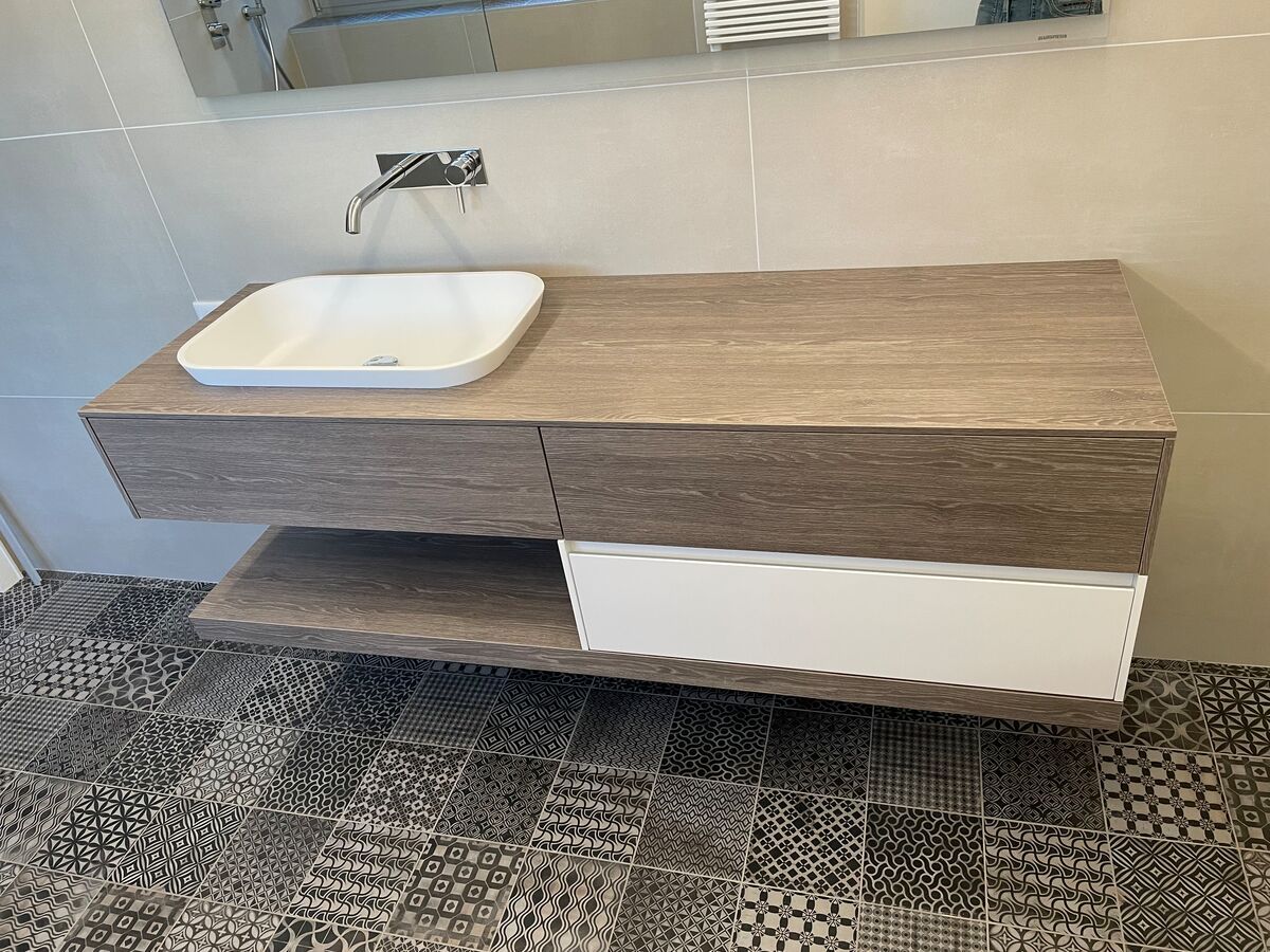 Une salle de bain avec un lavabo et un miroir au mur.