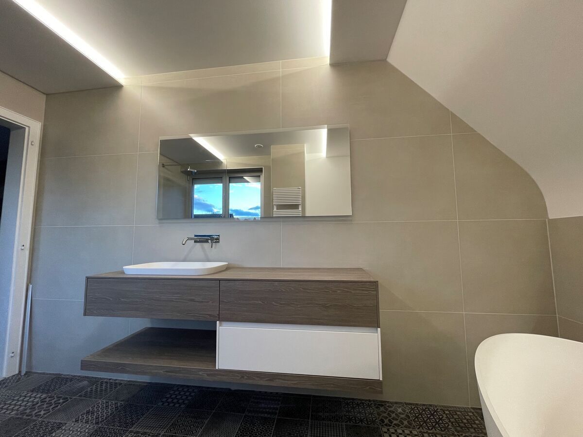 Une salle de bain avec lavabo, miroir et baignoire.