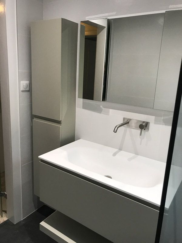 Une salle de bain avec un lavabo, un miroir et des armoires.