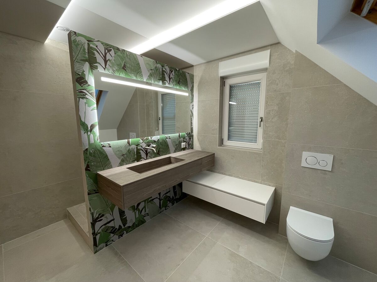 Une salle de bain avec lavabo, WC, miroir et fenêtre.