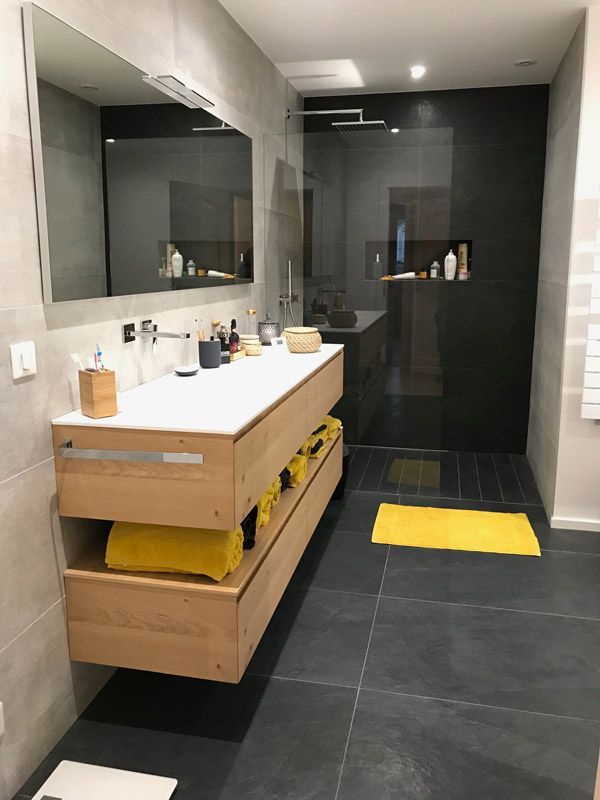 Une salle de bain avec deux lavabos et un grand miroir