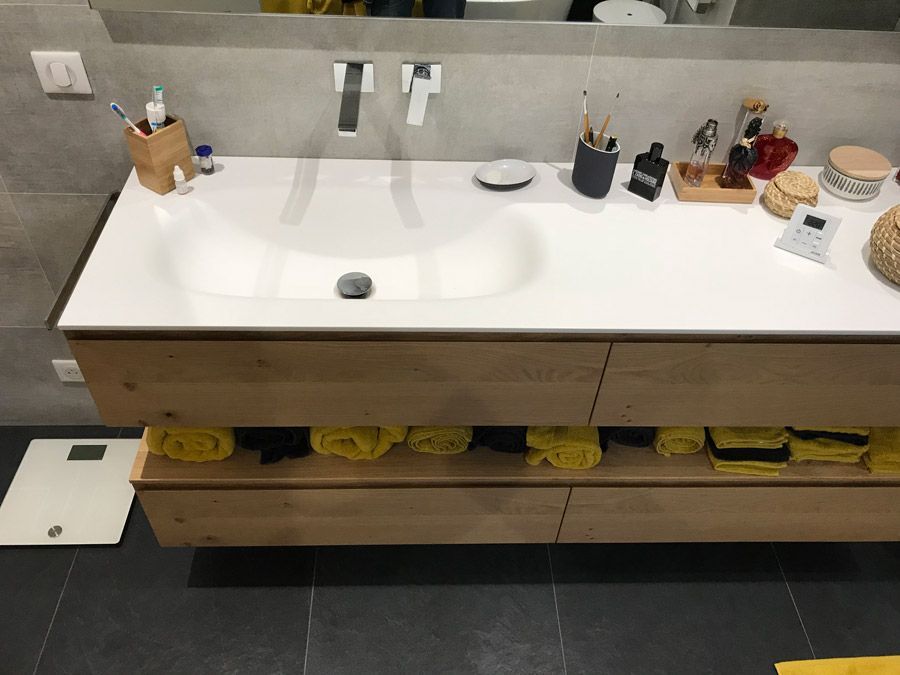 Une salle de bain avec un lavabo et une balance au sol