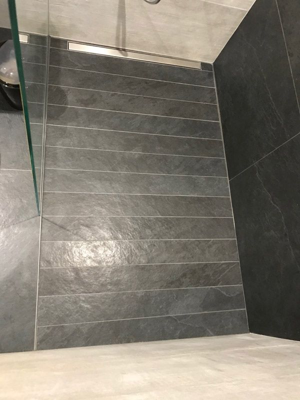 Une salle de bain avec douche à l'italienne et sol carrelé.