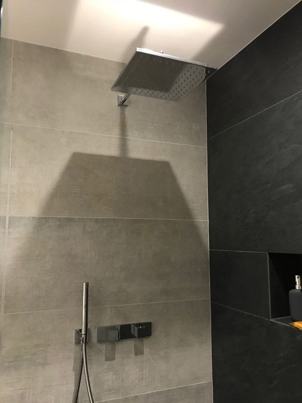 Une pomme de douche est suspendue au plafond dans une salle de bain.