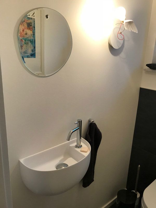 Une salle de bain avec un lavabo et un miroir au mur