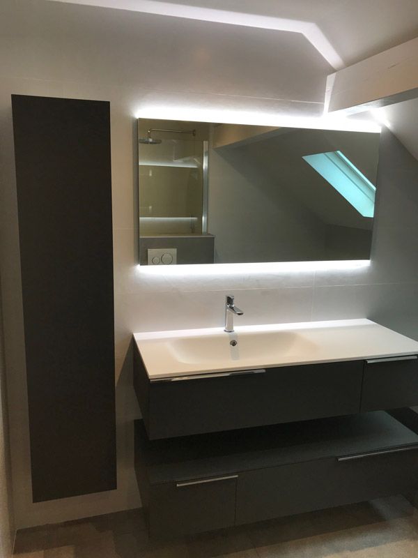 Une salle de bain avec un lavabo et un grand miroir
