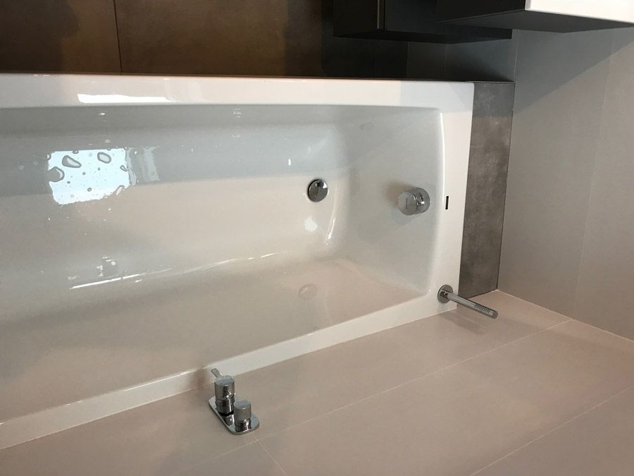 Une baignoire blanche est posée sur un comptoir blanc dans une salle de bain.