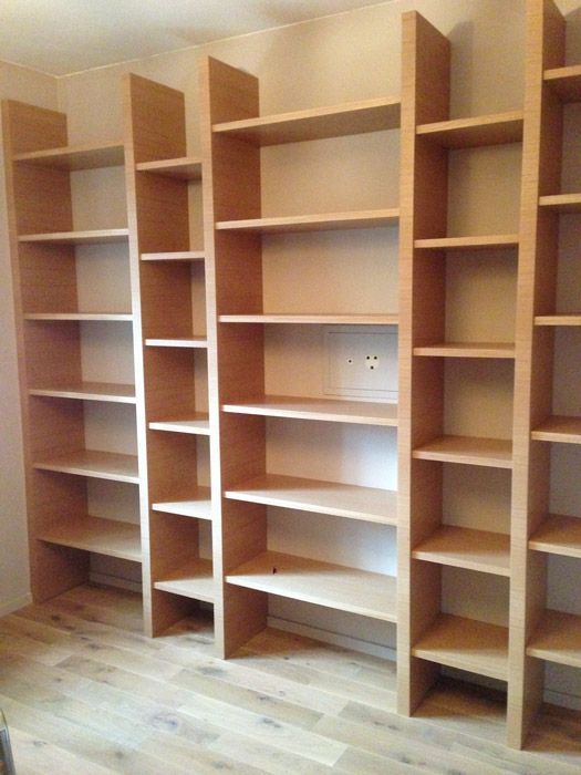 Une rangée d'étagères en bois dans une pièce