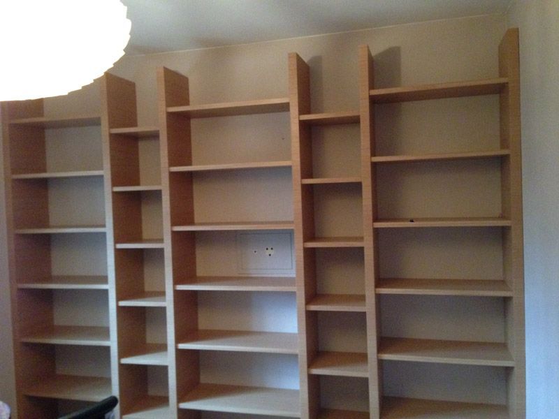 Une rangée d'étagères en bois dans une pièce