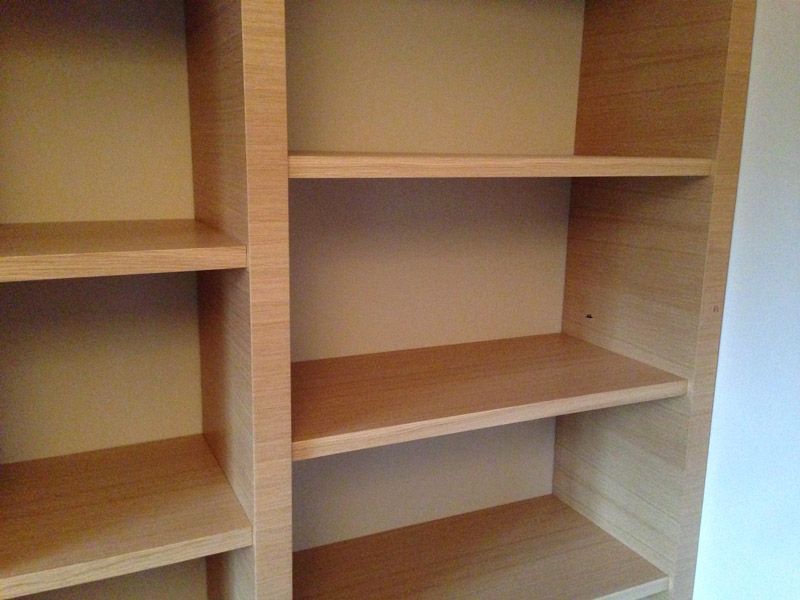 Une étagère en bois avec des étagères vides dans une pièce