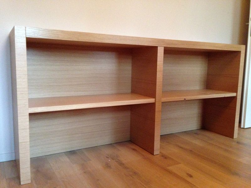 Une étagère en bois avec deux étagères dans une pièce