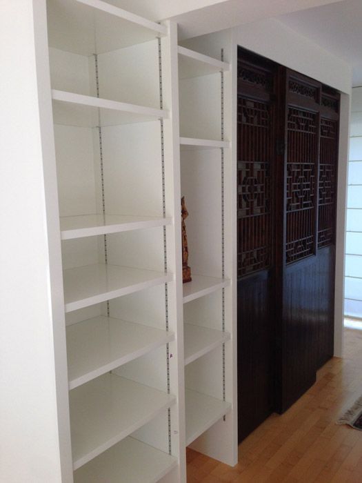 Une pièce avec beaucoup d'étagères et une statue au milieu